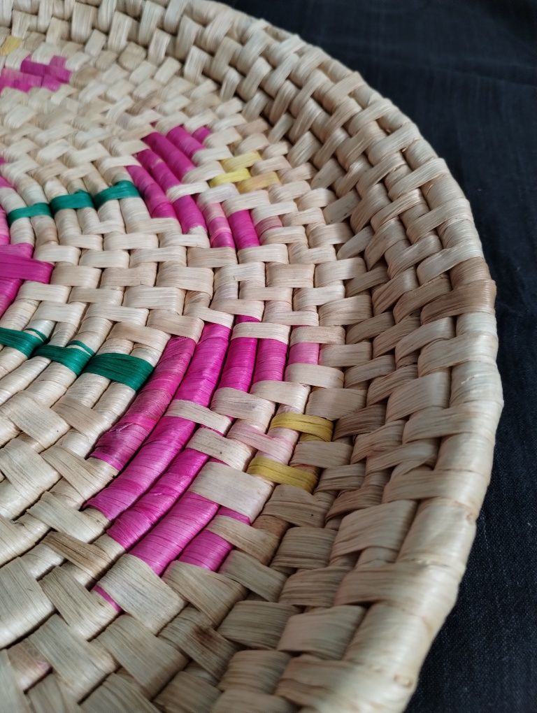 Bandeja artesanal em palha com motivos geométricos rosa e verde