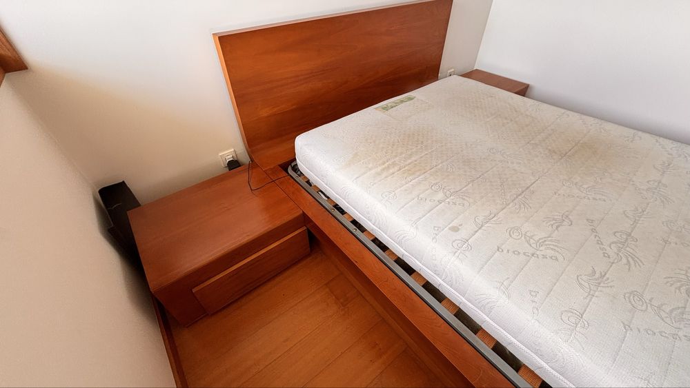 Cama casal com mesinhas de cabeceira e banco de apoio em cerejeira