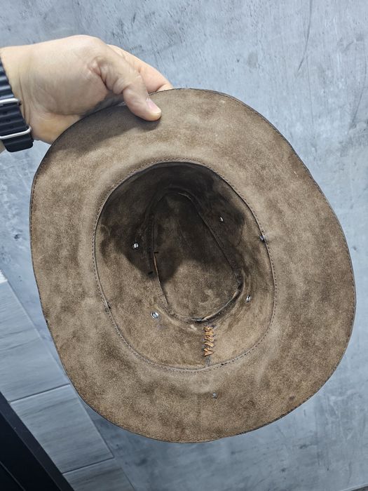 Skórzany australijski kapelusz bogato zdobiony.