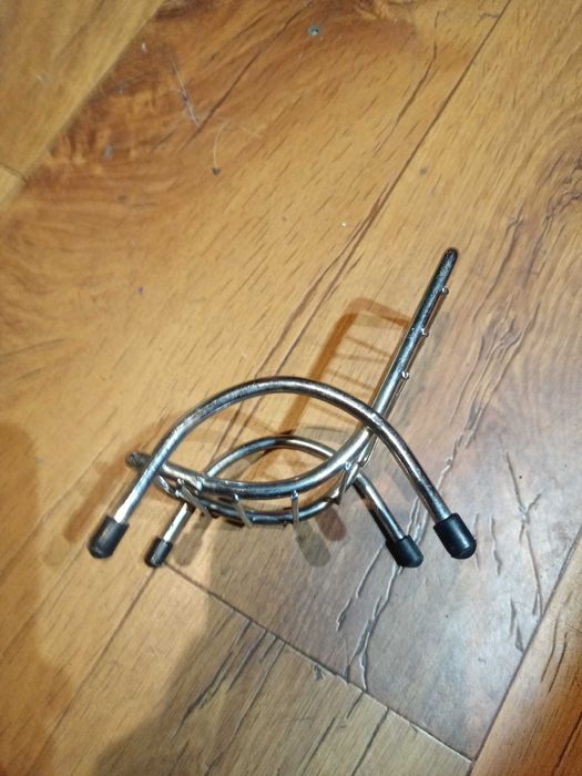 Metalowy stojak na dawny telefon komórkowy.