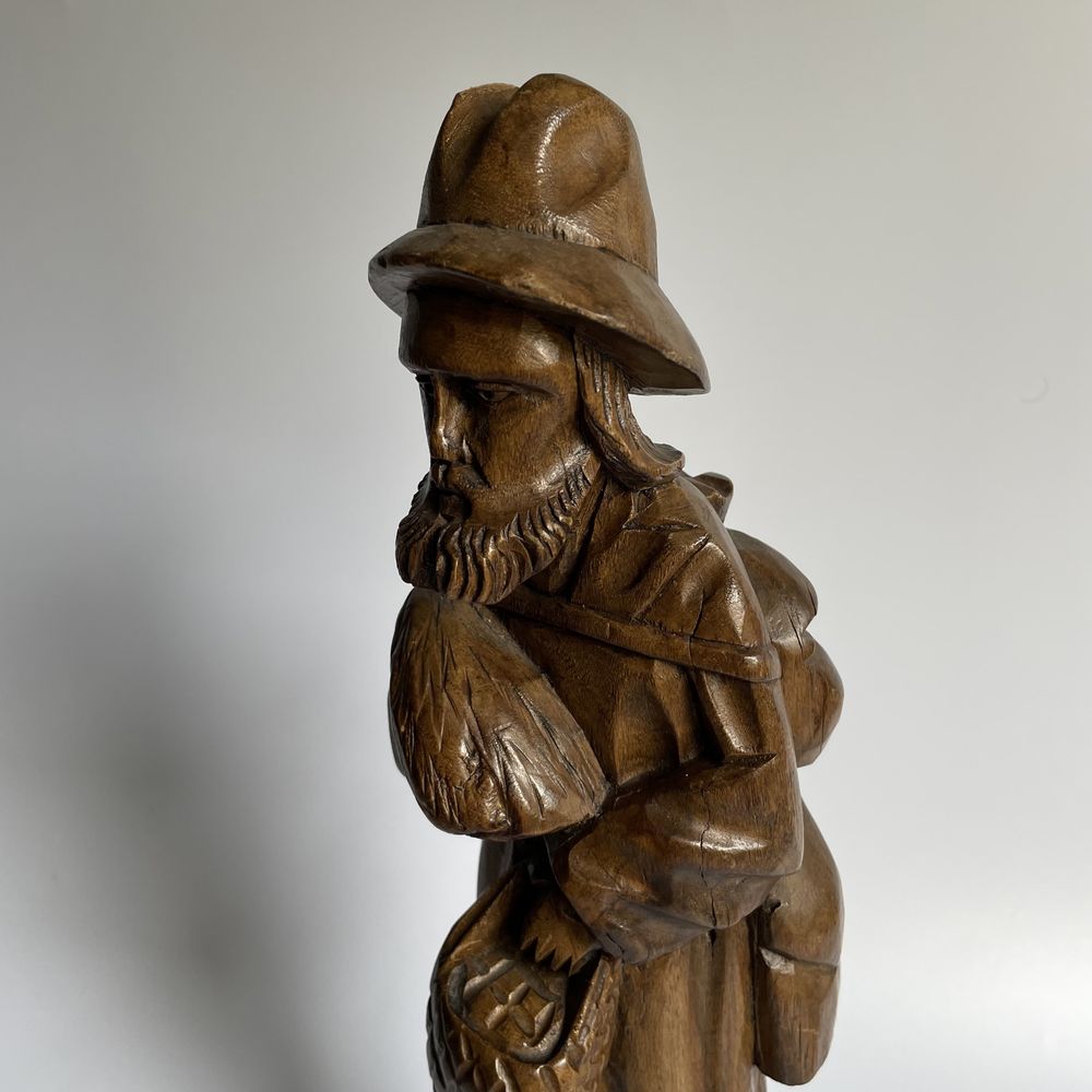 Stara rzeźba wędrowiec podróżnik piegrzym w kapeluszu z chlebem