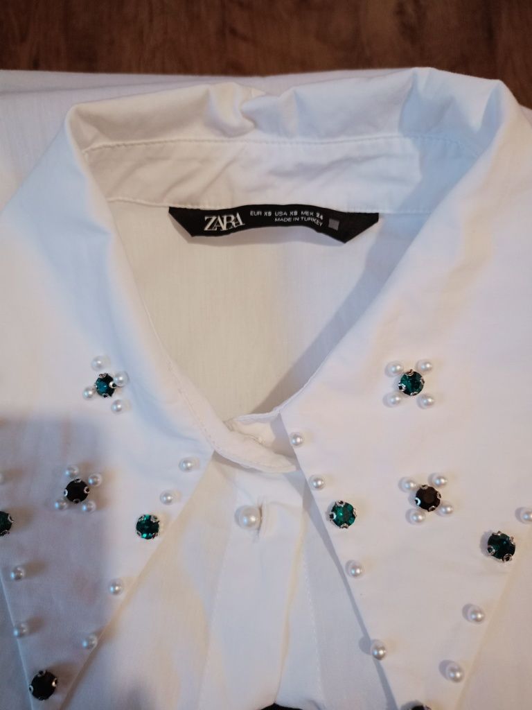Biała koszula z ozdobami Zara.