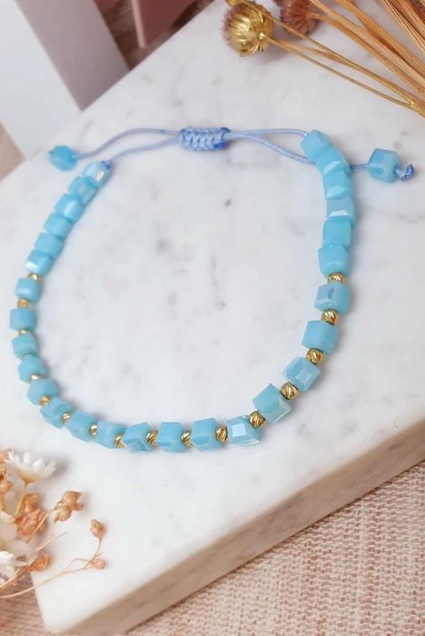 Bransoletka na sznureczku z niebieskimi koralikami.i I złotymi kulkami