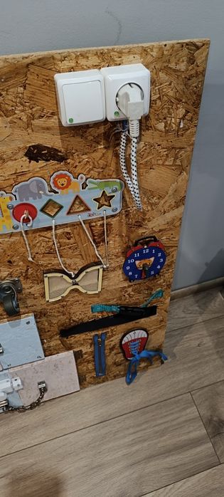 Tablica manipulacyjna zawiera elementy którymi dziecko może ćwiczyć zr