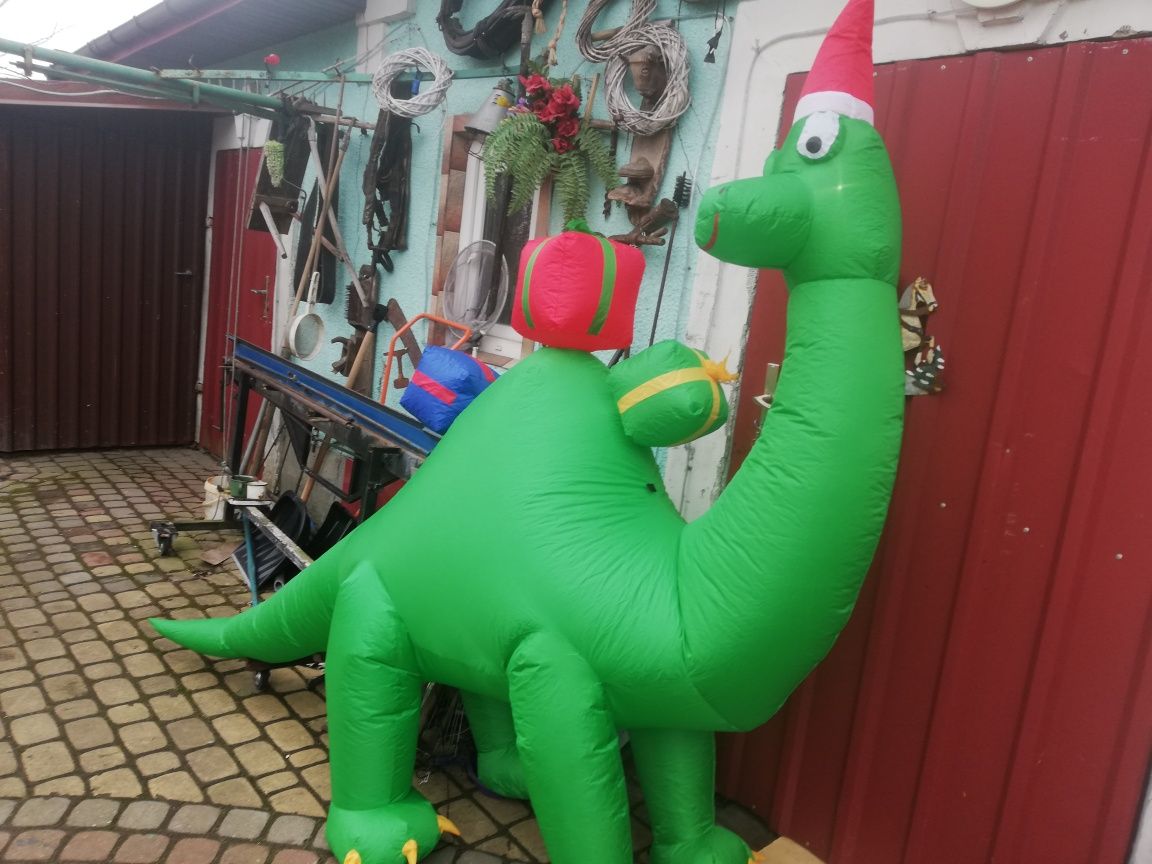 Świąteczny Dinozaur z prezentami i czapce czerwonej