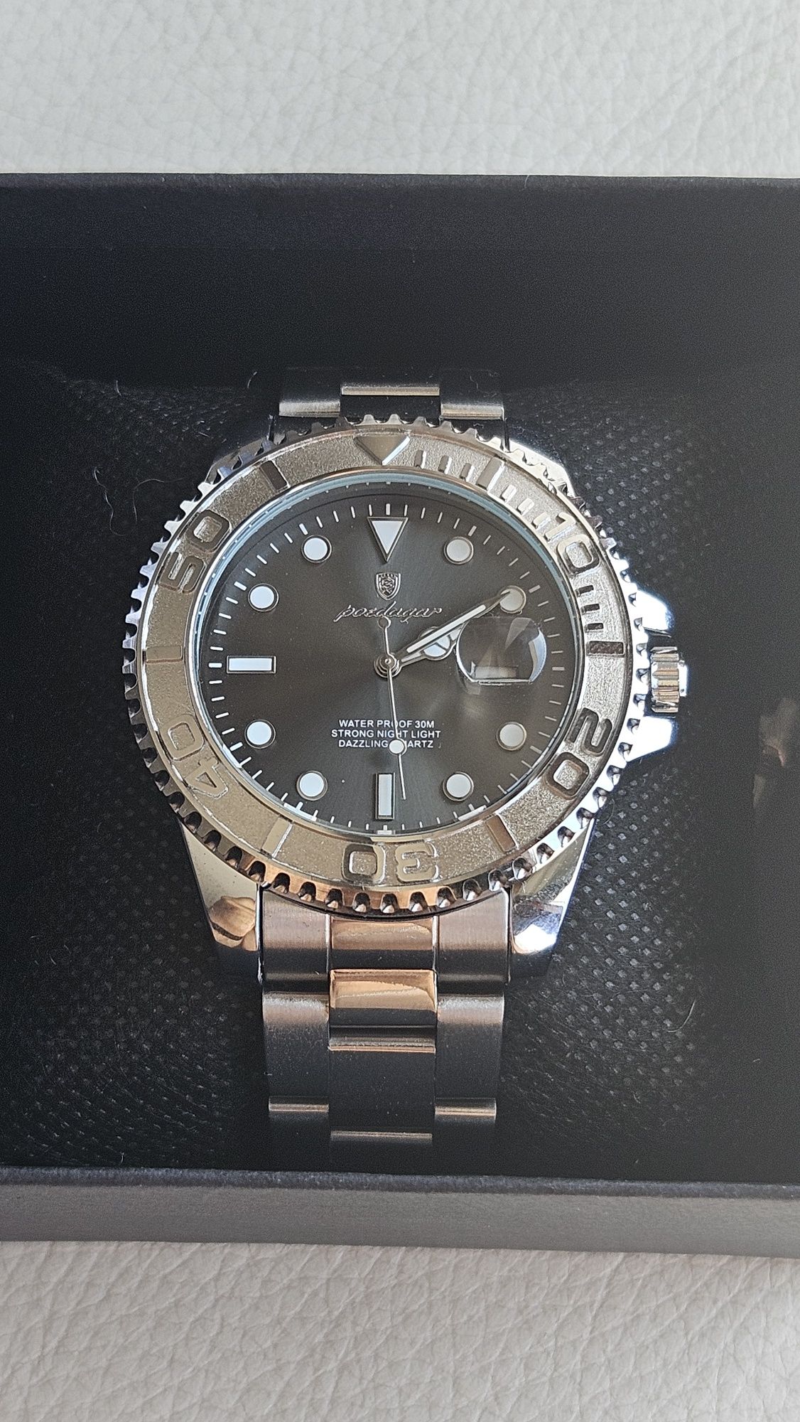 Relogio de luxo com mostrador preto e bezel prateado