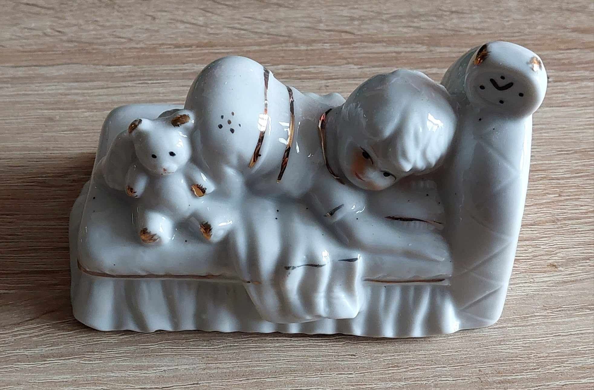 Porcelanowa figurka Bibelot. Dietsko w łóżku.