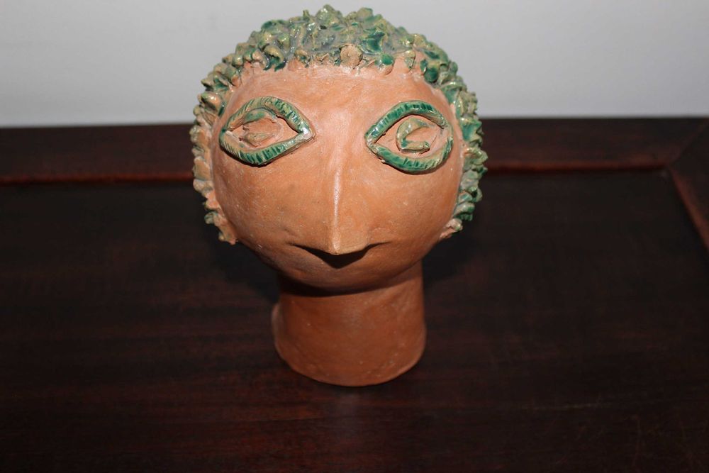 Escultura de barro representando rosto estilizado. 1977