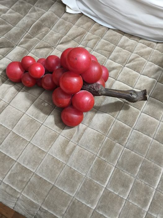 Uvas vermelhas em loiça com cacho em madeira