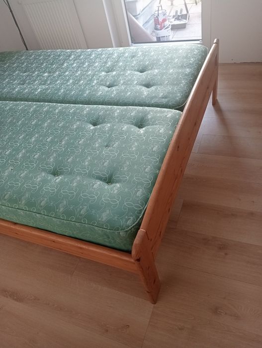 Łóżko dwuosobowe drewniane z dwoma materacami.