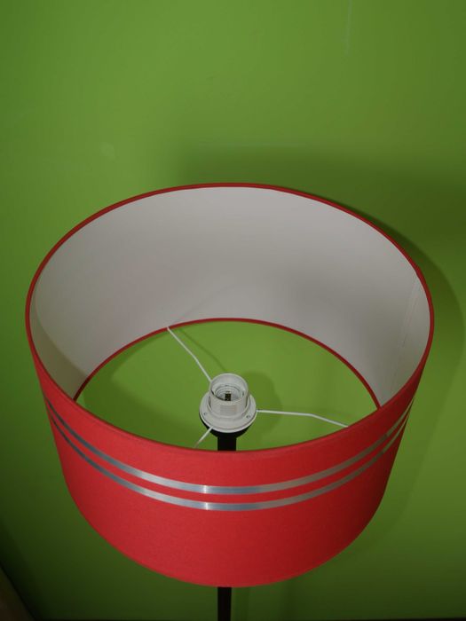 Lampa pokojowa wolnostojąca z czerwonym abażurem.