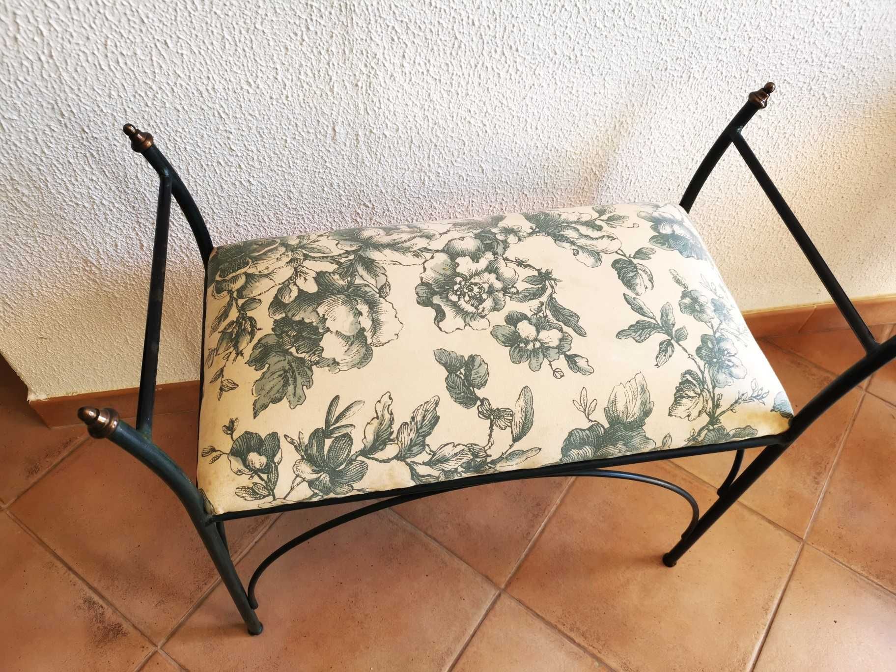 Assento com estrutura em ferro forjado e almofada fixa acolchoada.