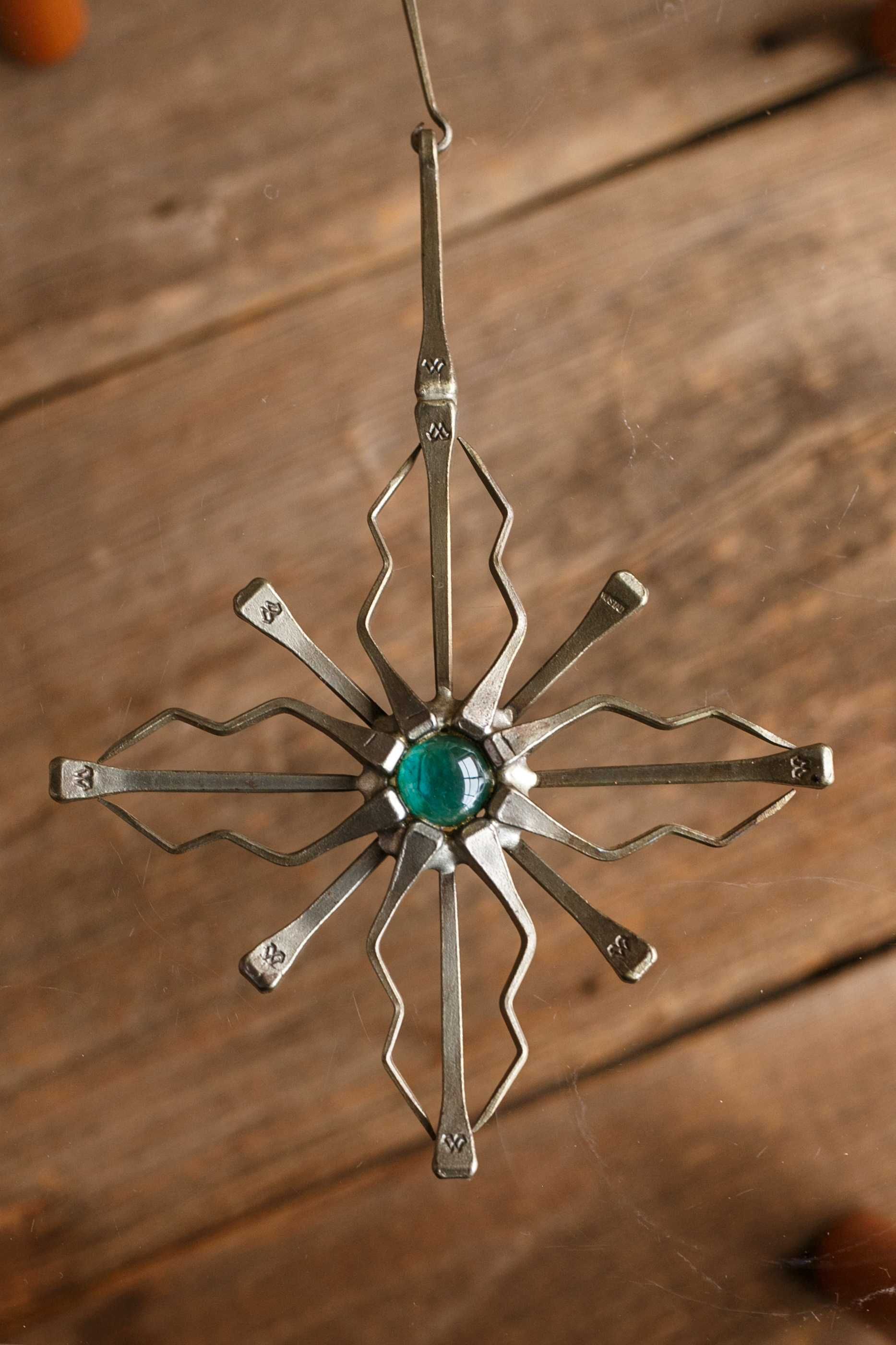 intrygująca metalowa dekoracja/krzyż ze szklanym oczkiem