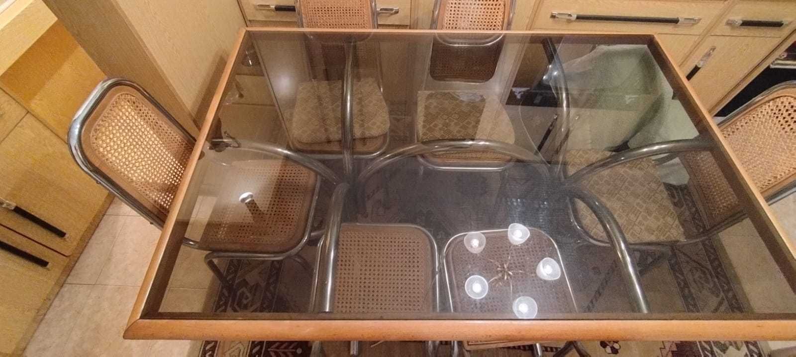 Mesa com tampo em vidro e rebordo de madeira.