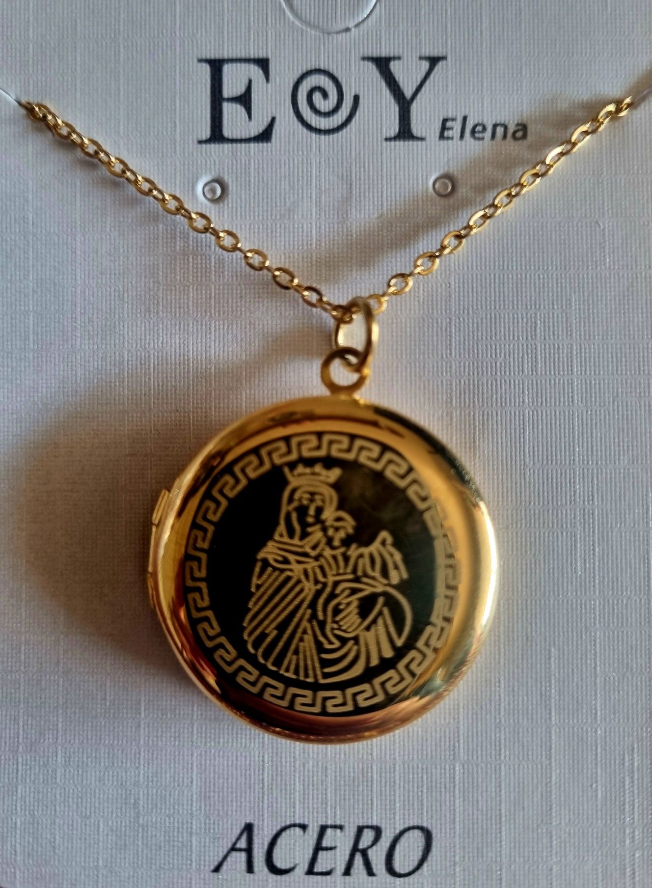Colar/relicário dourado, em aço, com a Nossa Senhora. Tem extensor
