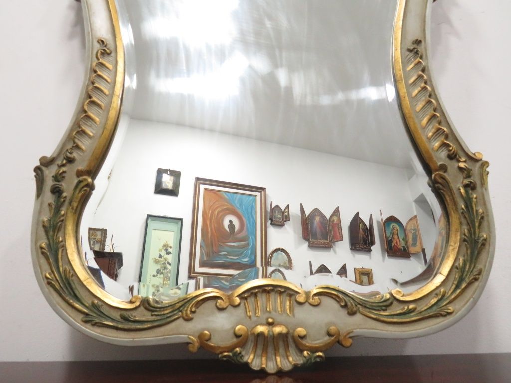 Espelho em madeira com detalhes dourados.