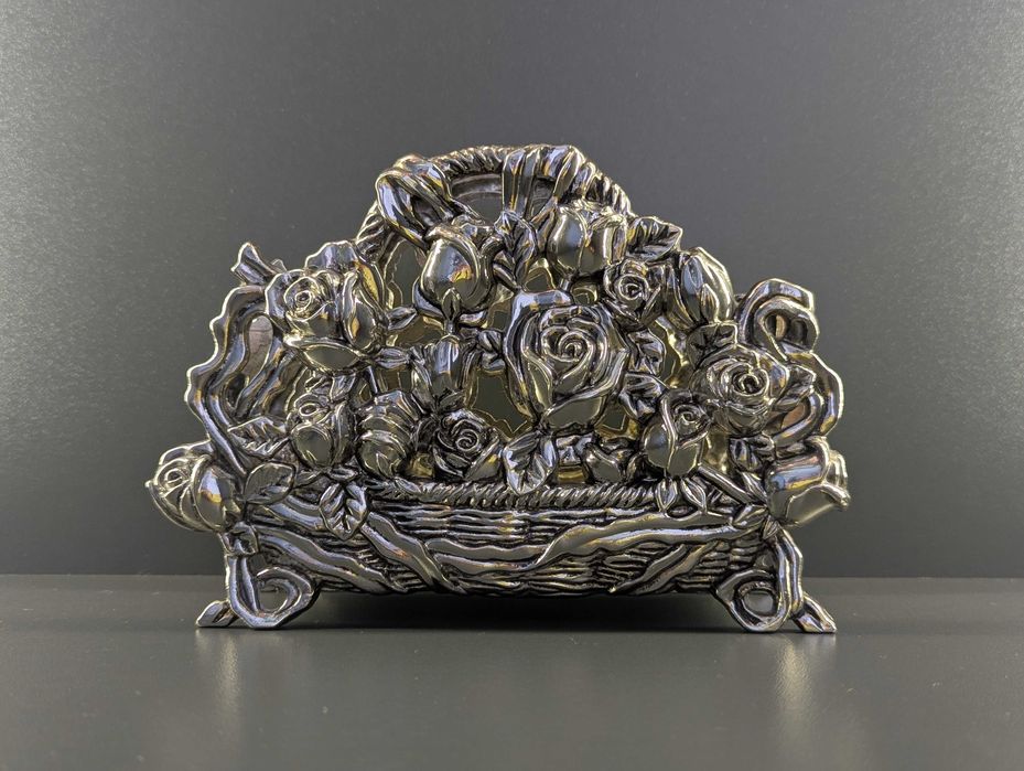 Шикарна посріблена серветниця з трояндами в конзрзині з бантами.