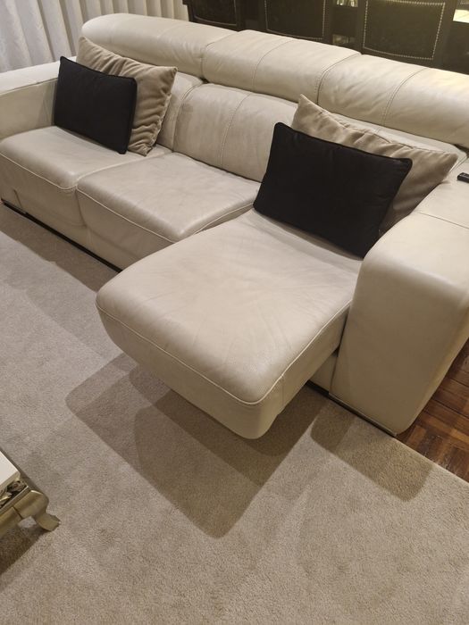 Sofá três lugares em pele beje.