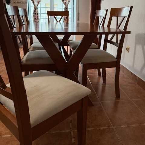 Conjunto de refeição com mesa e 6 cadeiras almofadadas.
