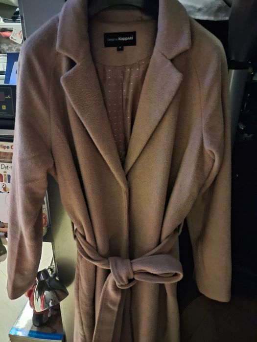 beżowy płaszcz z paskiem marki KappAhl.