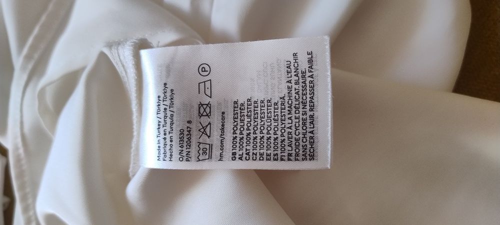 Szykowna, biała koszula z wiązaniem i makietami H&M
