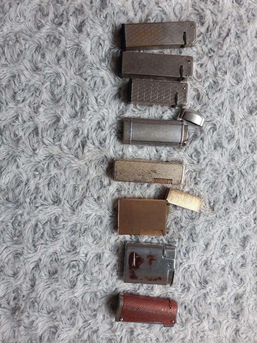 Zestaw zapalniczek kolekcjonerskich plus metalowy pojemnik na zapałki.