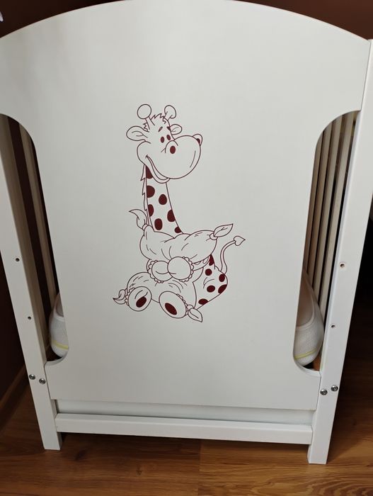 Łôżeczko dziecięce białe z szufladą, ozdobione motywem żyrafy. Materac