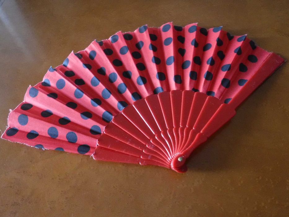 Leque vermelho e às bolas pretas