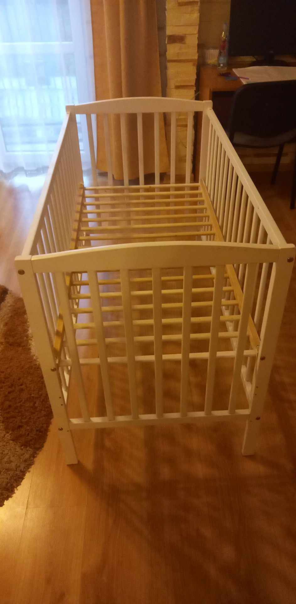 Białe łóżeczko ze szczebelkami