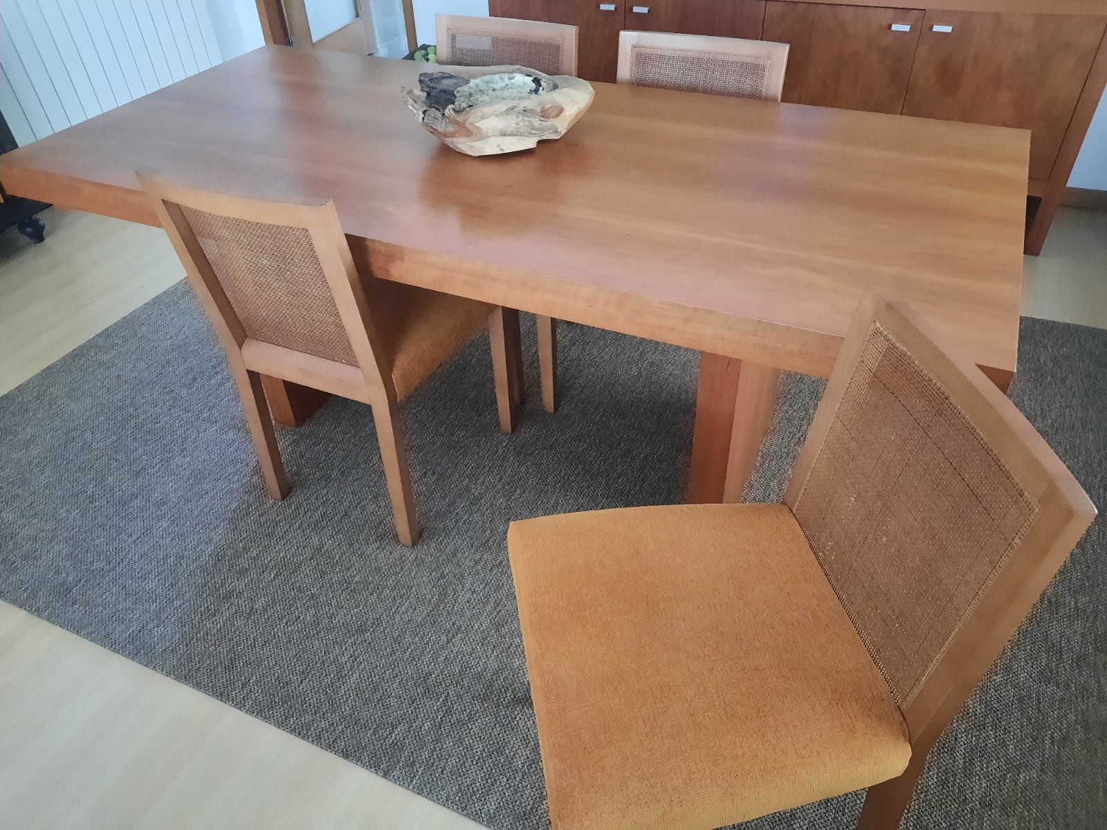 Mesa de madeira e cadeiras almofadadas