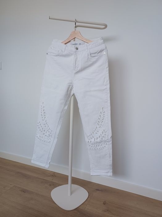 Calça branca com bordado recortado em padrão folhagem