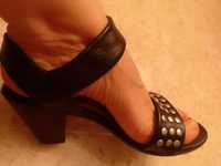 Sandálias pretas com apontamentos prateados.