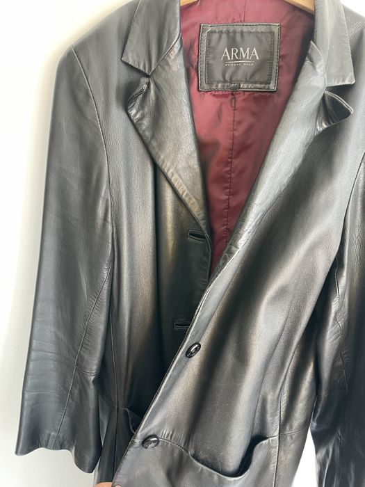 Casaco comprido de cabedal preto.