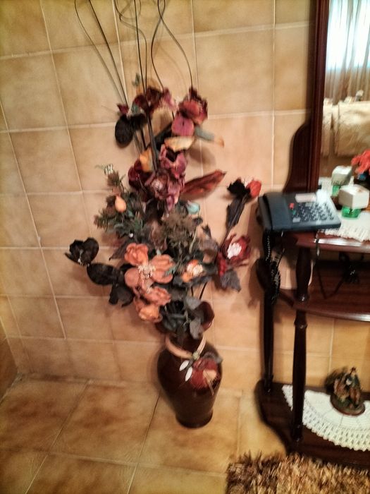 Pote com arranjo de flores e outros objetos