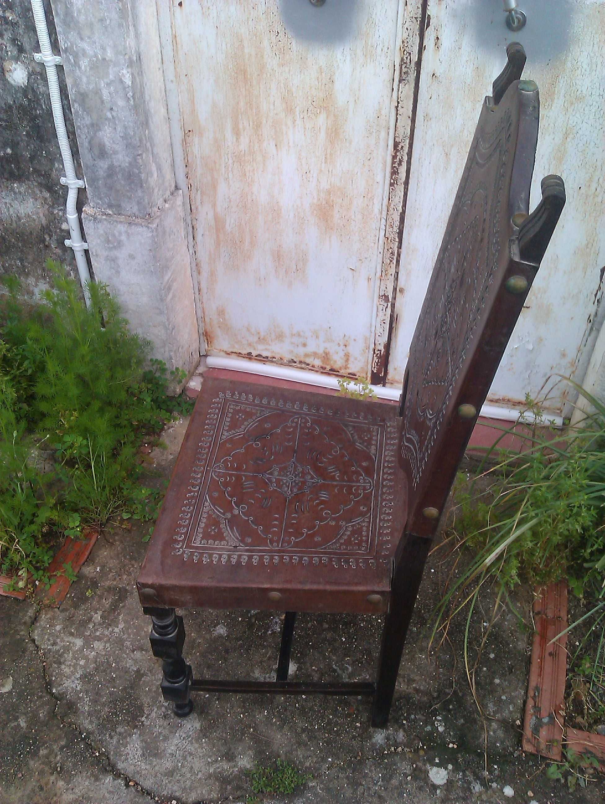 Cadeiras em mogno e couro trabalhado.