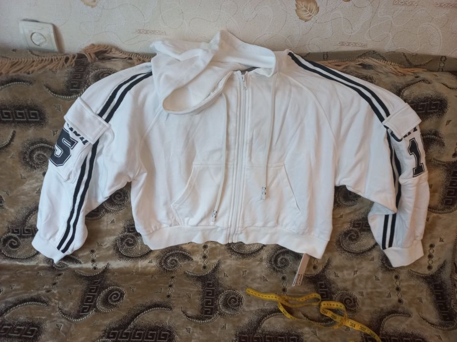 Стильниа зіпка-худі з лампасами та накладними кишенями на рукавах.