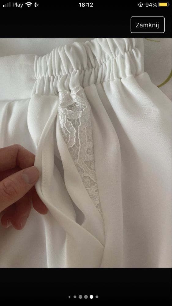 Białe eleganckie spodnie materiałowe z ozdobna koronkową w stawką przy