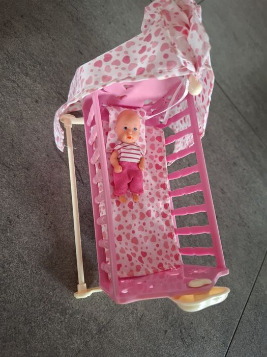 Mała lalka w kołysce z akcesoriami