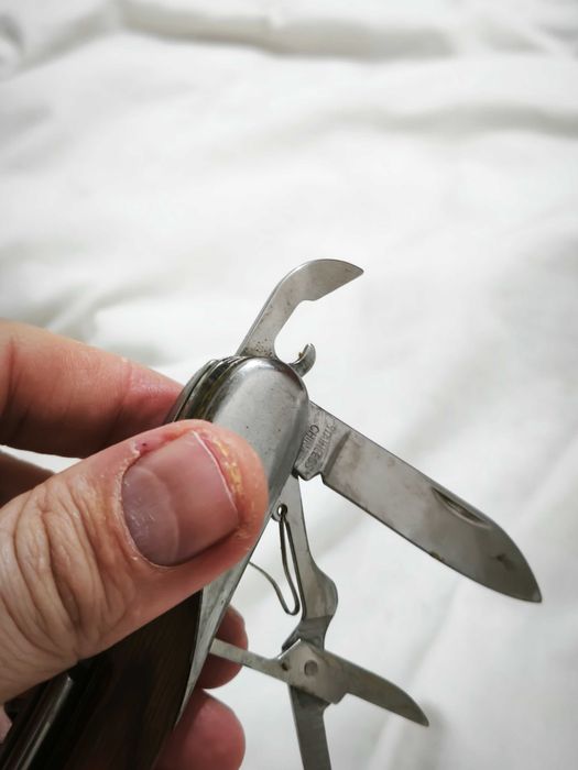 Canivete multifunções com acabamento em madeira e metal.