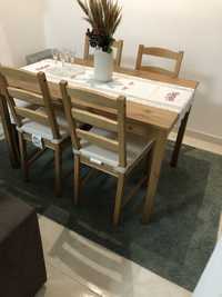 Mesa de jantar com cadeiras, tapete, sapateira e quadro.