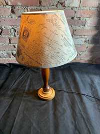 Stylowa lampa stołowa z drewnianą podstawą i abażurem z napisami