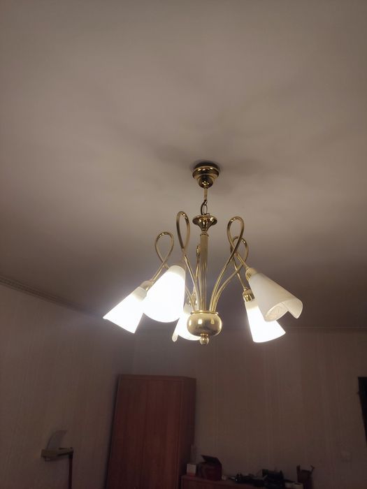 Żyrandol w kolorze złotym ze szklanymi białymi kloszami