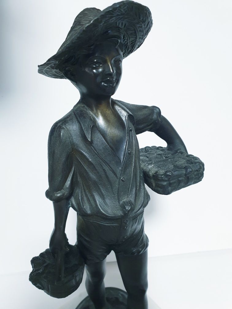 linda escultura de um rapaz a vender peixe em metal de fundição