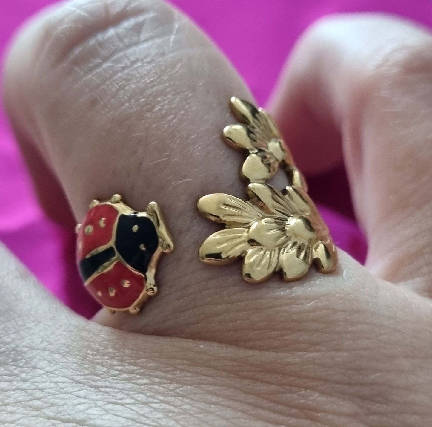 Anel dourado, em aço, com folhas e 1 joaninha. Ajustável