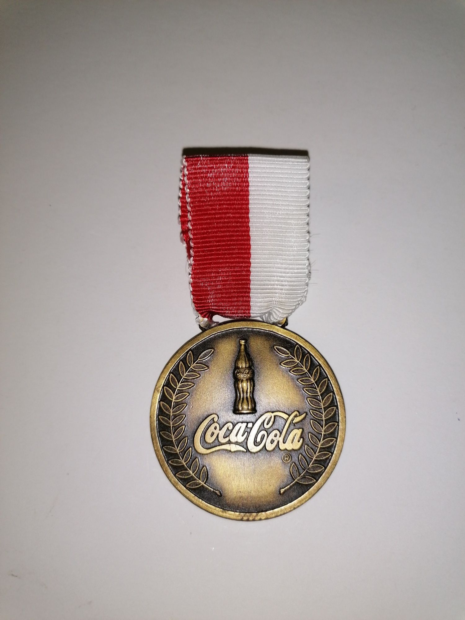 Medalha modelo condecoração em metal com a publicidade Coca Cola