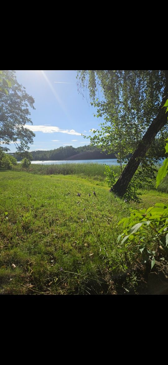 Domek nad jeziorem Rzuno z linią brzegową, łódką, kajakiem