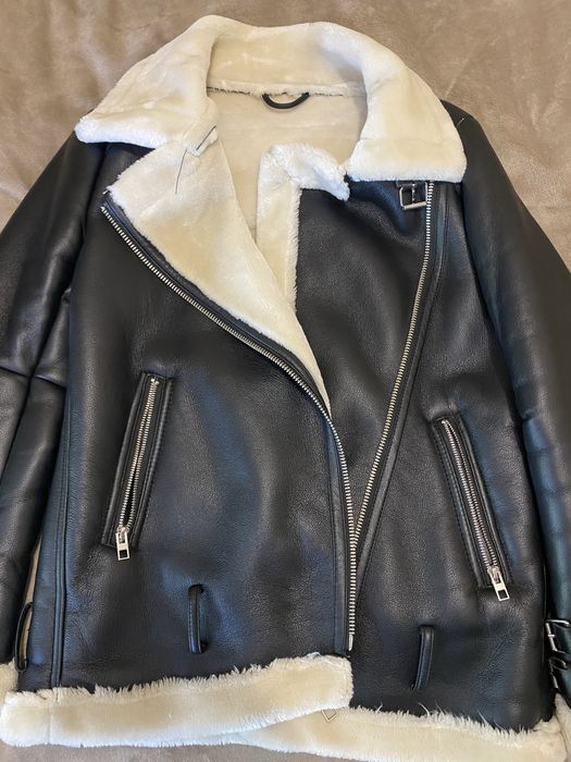 Жіноча дублянка чорного кольору з білим штучним хутром усередині.