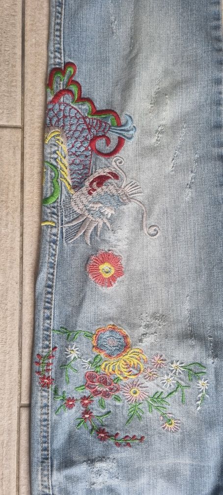 Spodnie jeansowe z aplikacjami w kwiaty marki Dolce &Gabbana