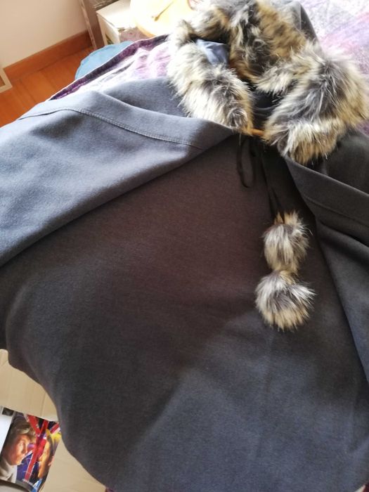 Capa com capuz e fita com pompons para apertar