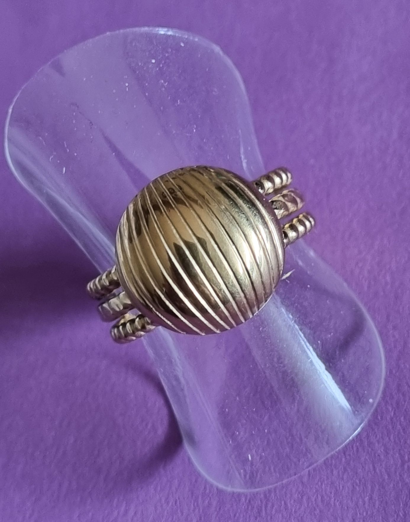 Anel dourado, em aço, com meia bola riscada. Ajustável